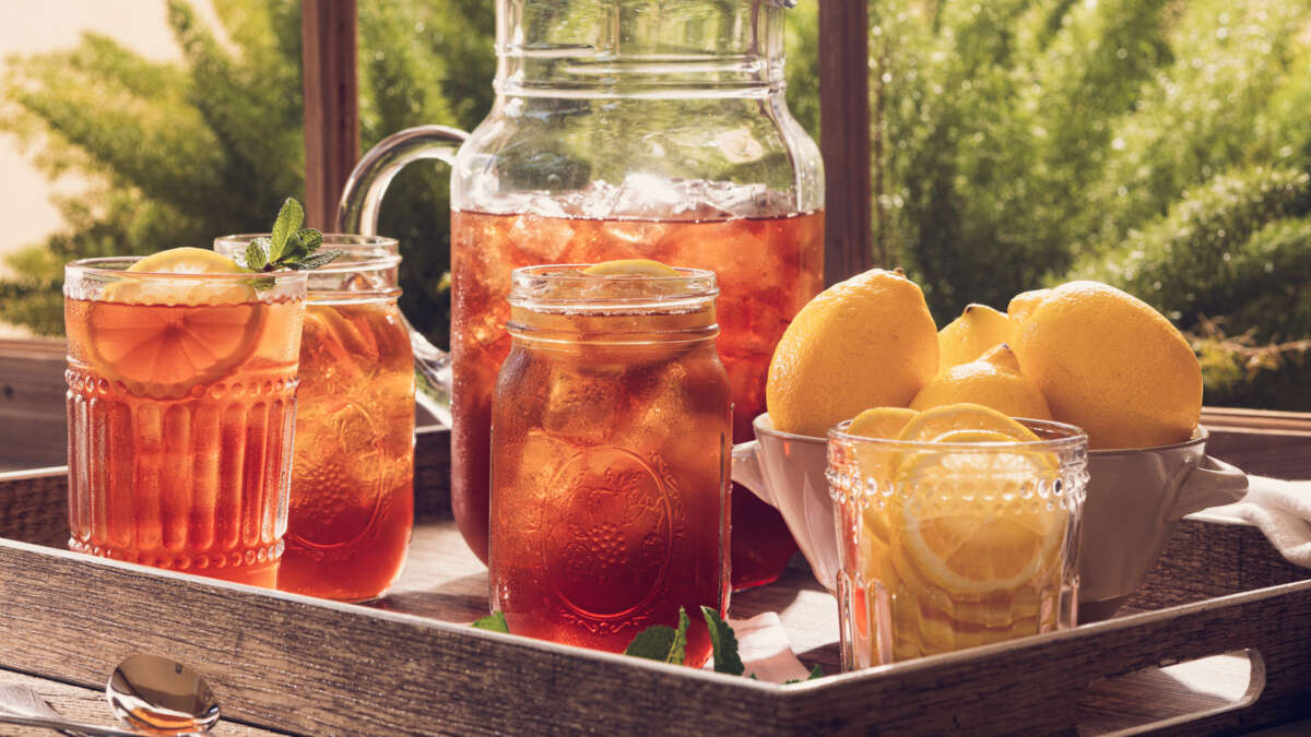 pitcher of iced tea and glasses on a tray on porch