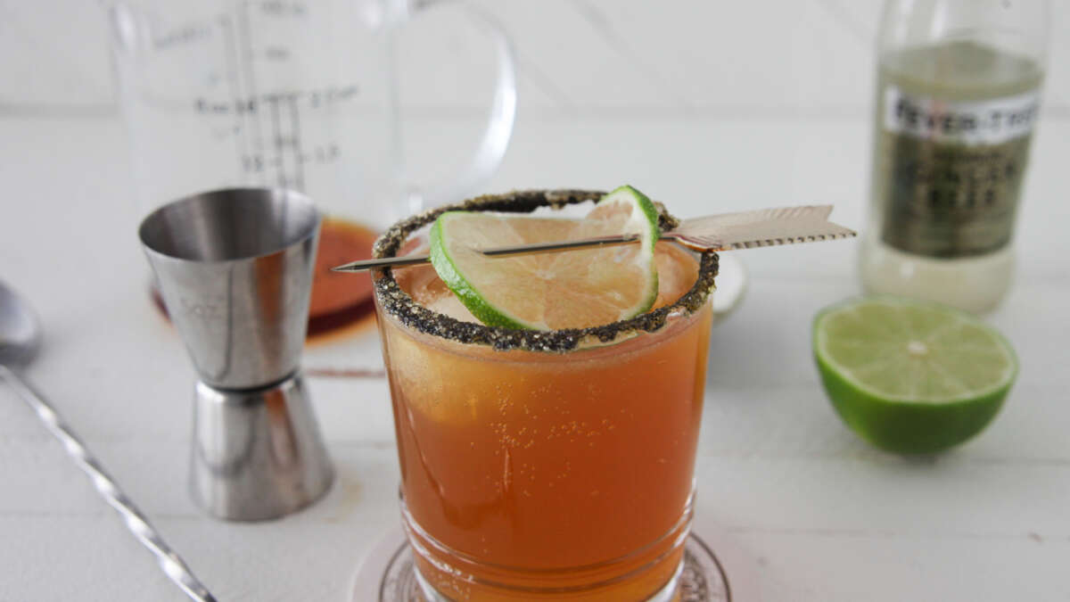 Stormy Brees cocktail in a glass, garnished with lime slice